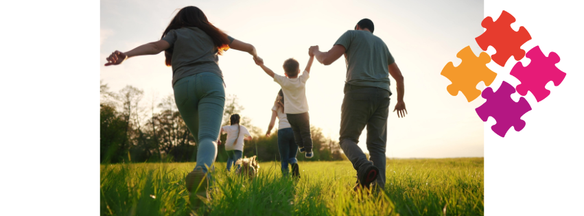 Happy family running through a meadow in the sunshine